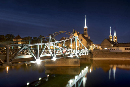照亮的桥梁的晚上相片和圣约翰浸礼会大教堂在波兰弗罗茨瓦夫