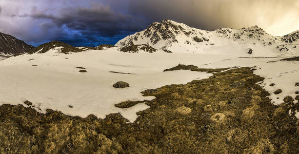 日落时白雪皑皑的高加索山脉与天空的风暴