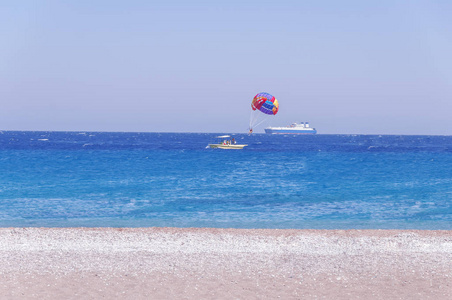 降落伞滑雪在蓝色波浪海和大船