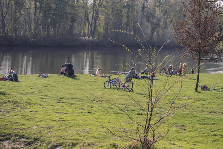人们在一条风景如画的河岸边的娱乐区休息。