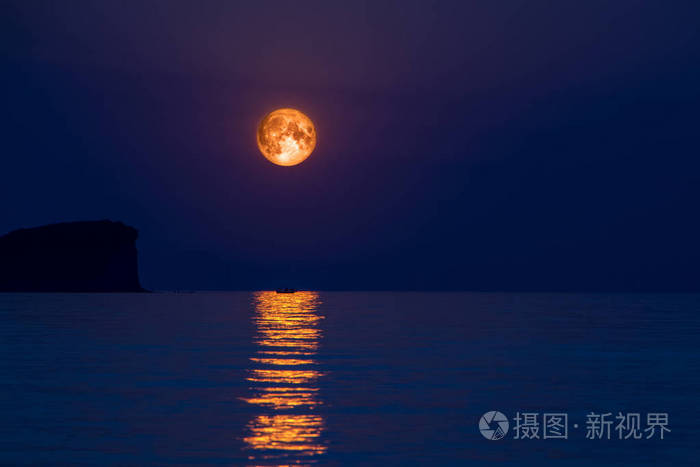 满月在海与抽象闪耀的水和小船剪影在月光反射