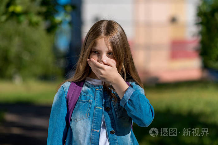 一个金发碧眼的小女孩用手捂住她的嘴巴.害怕恐惧的情绪.