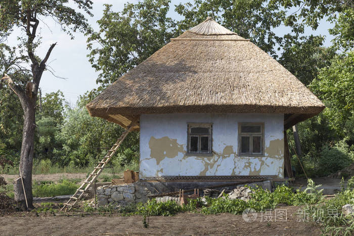 传统的 moldovian 乡村住宅.房子在屋顶下从芦苇和一个老梨