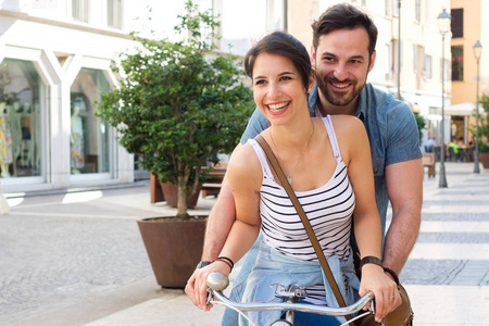 年轻夫妇在城市旅行与自行车共享运输