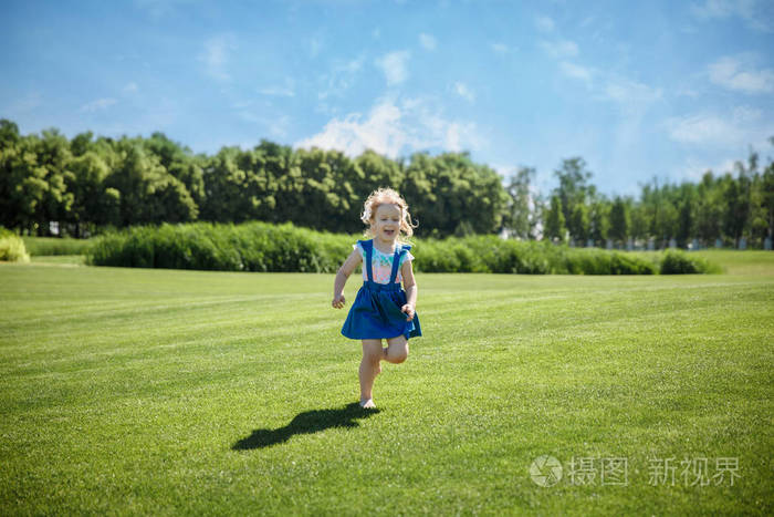 一个小女孩在公园里奔跑.