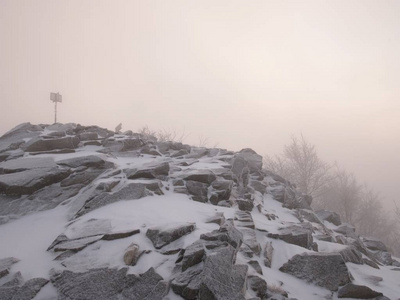 秋天的山顶上布满了第一层积雪, 藏在薄雾或云层中。强风的危险天气