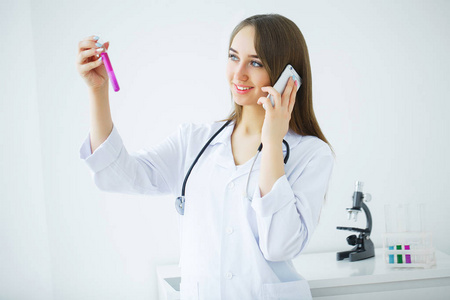 女性医疗或研究科学家或使用明确的解决方案，在实验室或实验室测试管看医生