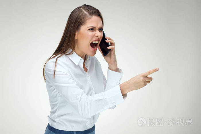 愤怒的女商人用手机和手指指着的情绪喊叫