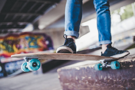 裁剪的年轻男子滑板图像。男青少年与长板在 skatepark