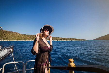 美丽的女孩在帽子放松在船上, 看着岛上。土耳其旅游职业巡回赛