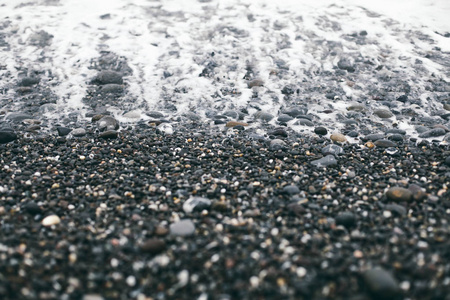 背景海岸与盐海小石头洗涤由白色波浪
