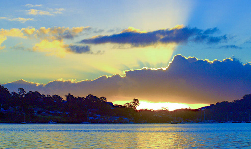 一个引人注目的黄色的阳光日出海景的海水与水的反射。澳大利亚昆士兰