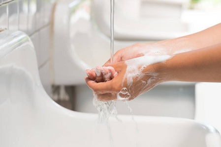 浴室里有水的女人用肥皂洗手