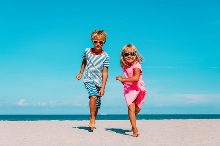 快乐的孩子男孩和女孩在海滩上奔跑