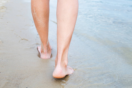 女人走进大海, 身体的一部分, 完美的日光浴女人的腿, 享受在海滩上的时间, 暑假概念