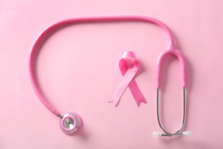 粉红色丝带和听诊器的颜色背景。乳癌意识概念