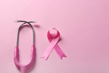 粉红色丝带和听诊器的颜色背景。乳癌意识概念
