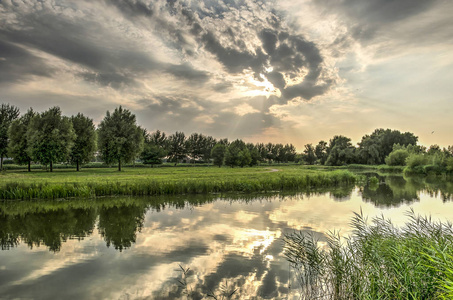 在鹿特丹以南的 Ijsselmonde 岛 Koedood 河平静的水中反射出戏剧性的夜空