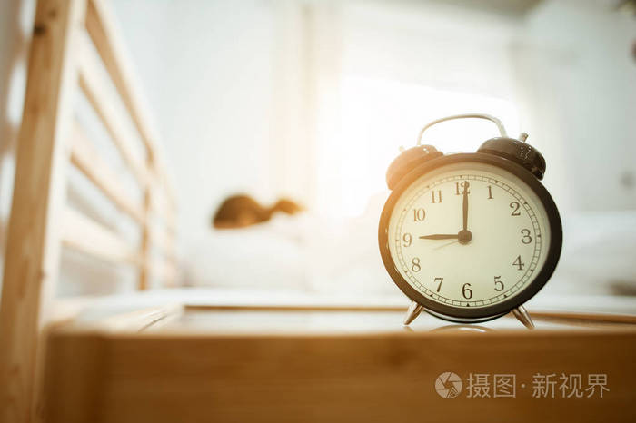 特写闹钟在床上醒来后, 阳光在清晨