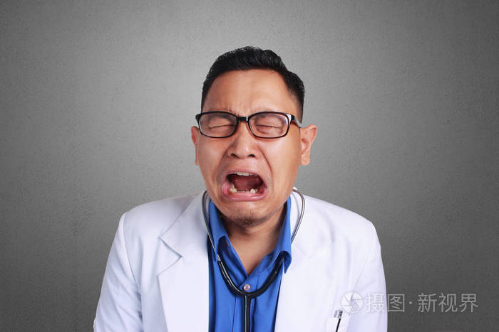 一位年轻的亚洲医生, 戴着眼镜.哭泣或哀伤的概念