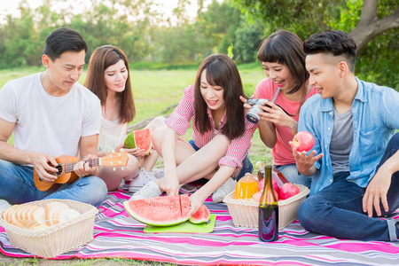 人们愉快地吃西瓜和享受野餐