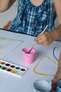 儿童的手画与彩色水彩在白色桌面背景。教育理念