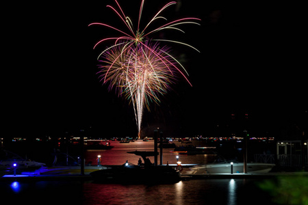 7月4日美丽的烟花在爱达荷州的湖心科达伦上闪闪发光, 几条小船拥挤在水和码头上。