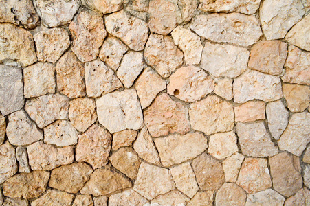 质地的石墙, 道路从石头, 砖块, 鹅卵石, 瓷砖与砂缝的灰色古代自然老黄与尖锐的边缘。的背景