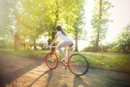 女孩骑自行车在日落