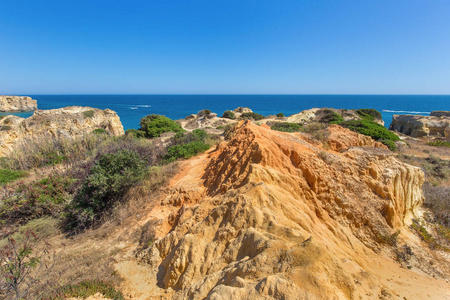 葡萄牙海岸的橙岩山和绿色植物