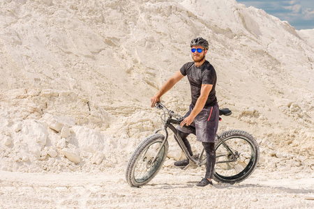 在白垩采石场训练一自行车。在一辆肥胖的自行车上的野蛮人