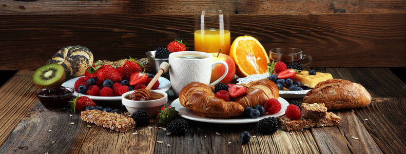 桌上有华夫饼牛角面包咖啡和果汁的早餐