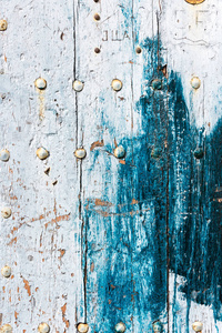 在白色和蓝色的墙壁或地板风化旧的破旧的木纹木板与生锈的指甲作为背景