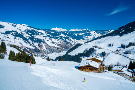 美丽的滑雪胜地在山的中间在奥地利阿尔卑斯。壮观的冬天山看法与小木房子和山坡