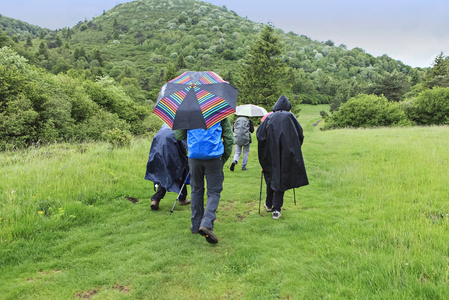 徒步旅行者小组在雨下漫步