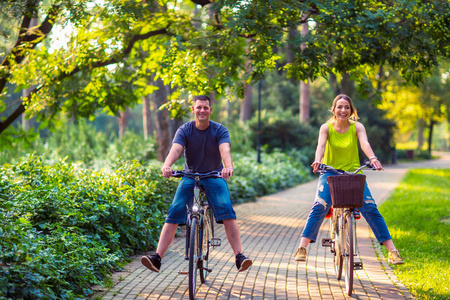 幸福的家庭。快乐活泼的父亲和母亲与孩子在自行车在公园乐趣