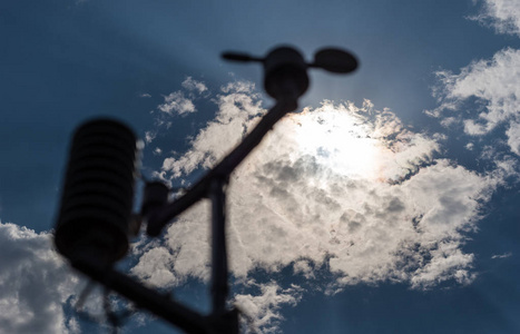 家乡的气象站在蓝天的背景下与太阳在云层后面。温度湿度和风向的测量