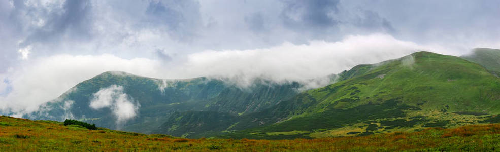 山脊和高地谷的宽广的全景与湖在阴云密布的天气在