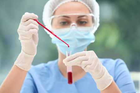 科学家将血液滴入实验室中的试管中