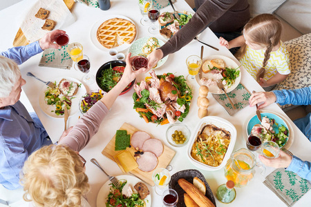 在节日庆祝活动中, 大幸福的家庭坐在餐桌上享用美味的自制食物的美景