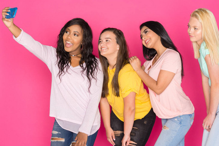 四组青少年女孩在粉红色背景下一起玩