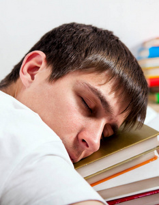 累了的学生睡在沙发上的书籍