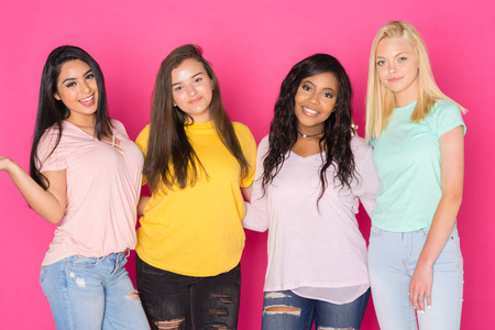 四组青少年女孩在粉红色背景下一起玩