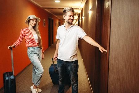 带手提箱的快乐情侣在找他们的旅馆房间。旅行或旅游概念, 暑假