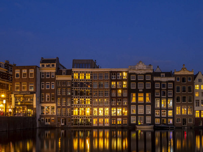 Damrak 的传统运河别墅在阿姆斯特丹的黄昏时分。运河上的建筑物是传统的荷兰建筑形式, 现在很受欢迎。