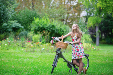 快乐的年轻女孩与自行车和花
