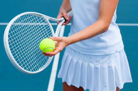 网球运动员在网球场上的手里拿着网球拍和球