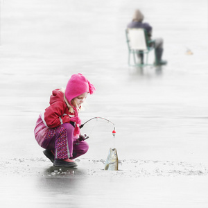 小孩子在冬天结冰的湖面上钓鱼