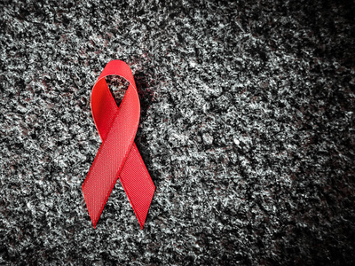 在花岗岩上的红丝带，世界艾滋病日的概念