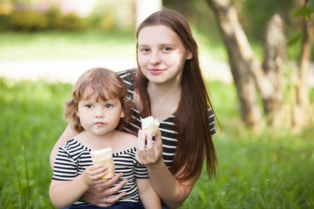 母亲和女儿蹒跚学步的冰淇淋